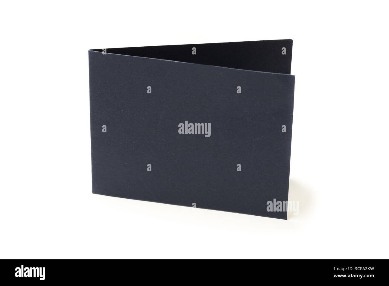Semplice cartella nera seduta su una superficie bianca in una sala luminosa durante il giorno Foto Stock