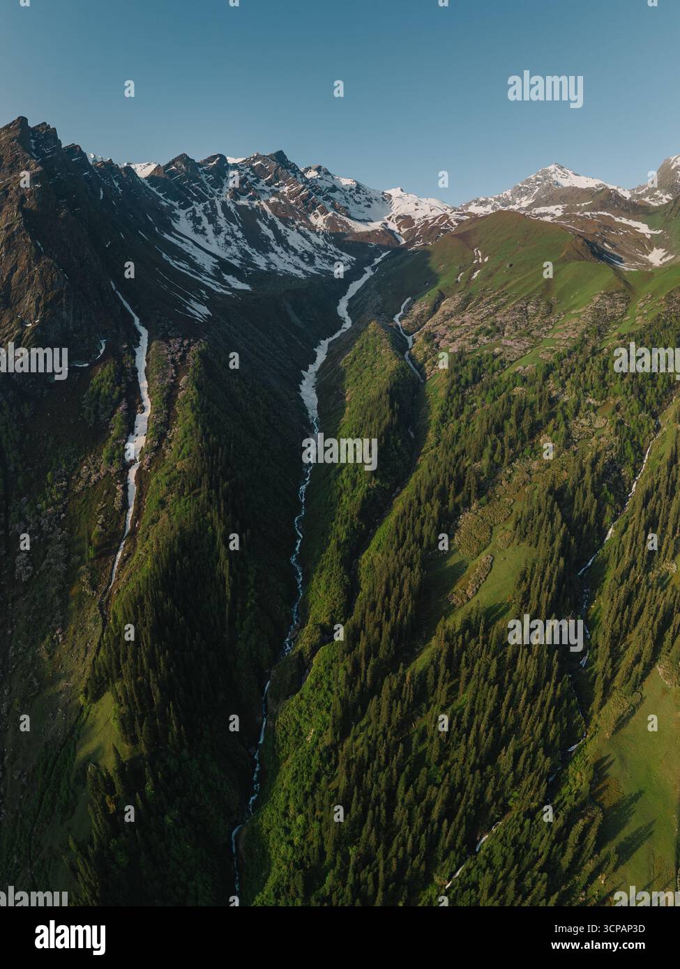 Vista aerea di aspre montagne con macchie di neve aggrappate alle cime e valli verdeggianti, una sinfonia della grandezza della natura, Sosan, Himachal Prad Foto Stock