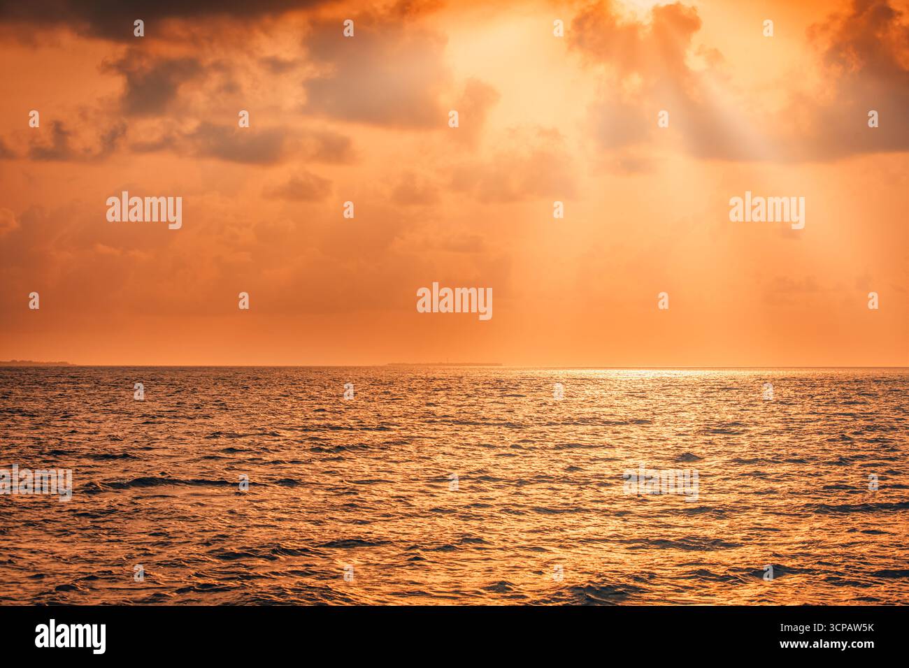 Il fantastico tramonto dorato sul mare calmo con cielo spettacolare, nuvole morbide e raggi luminosi del sole sognano un tranquillo sfondo naturale e una tranquilla vista sul mare Foto Stock