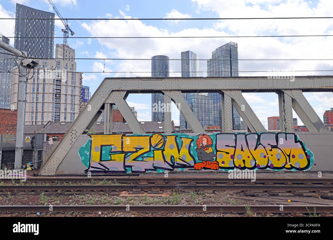 Graffiti sul ponte ferroviario di Manchester Castlefield, con alti appartamenti sullo sfondo, Greater Manchester, Inghilterra, Regno Unito Foto Stock