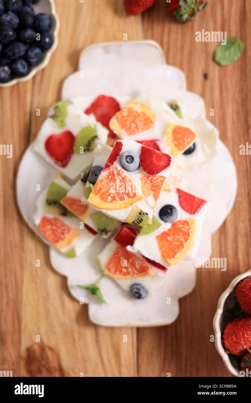 Corteccia di yogurt congelato con frutti di bosco su un tavolo di legno, vista dall'alto Foto Stock