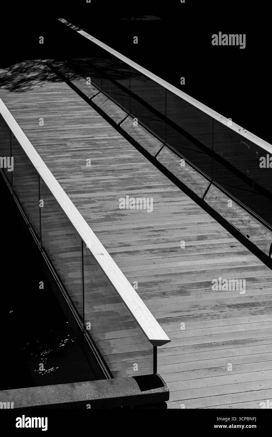 Passerella in bianco e nero con ringhiere e riflessi in vetro, passerella monocromatica con ringhiere in vetro e riflessi Foto Stock
