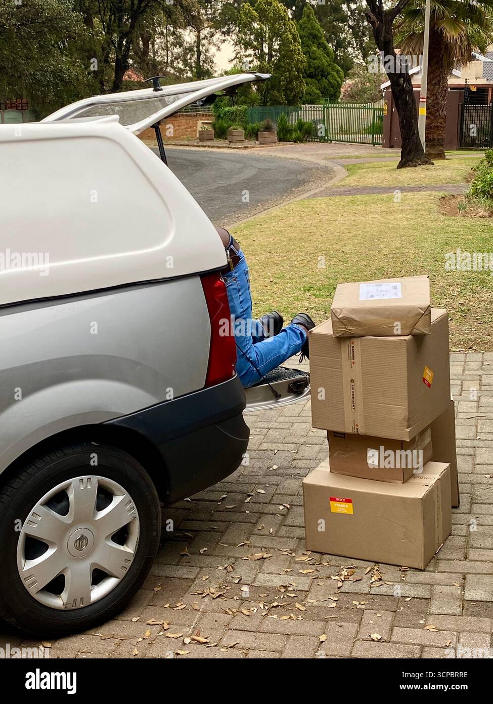 Johannesburg, Sud Africa - un corriere non identificato consegna articoli per lo shopping online in una casa privata in città Foto Stock
