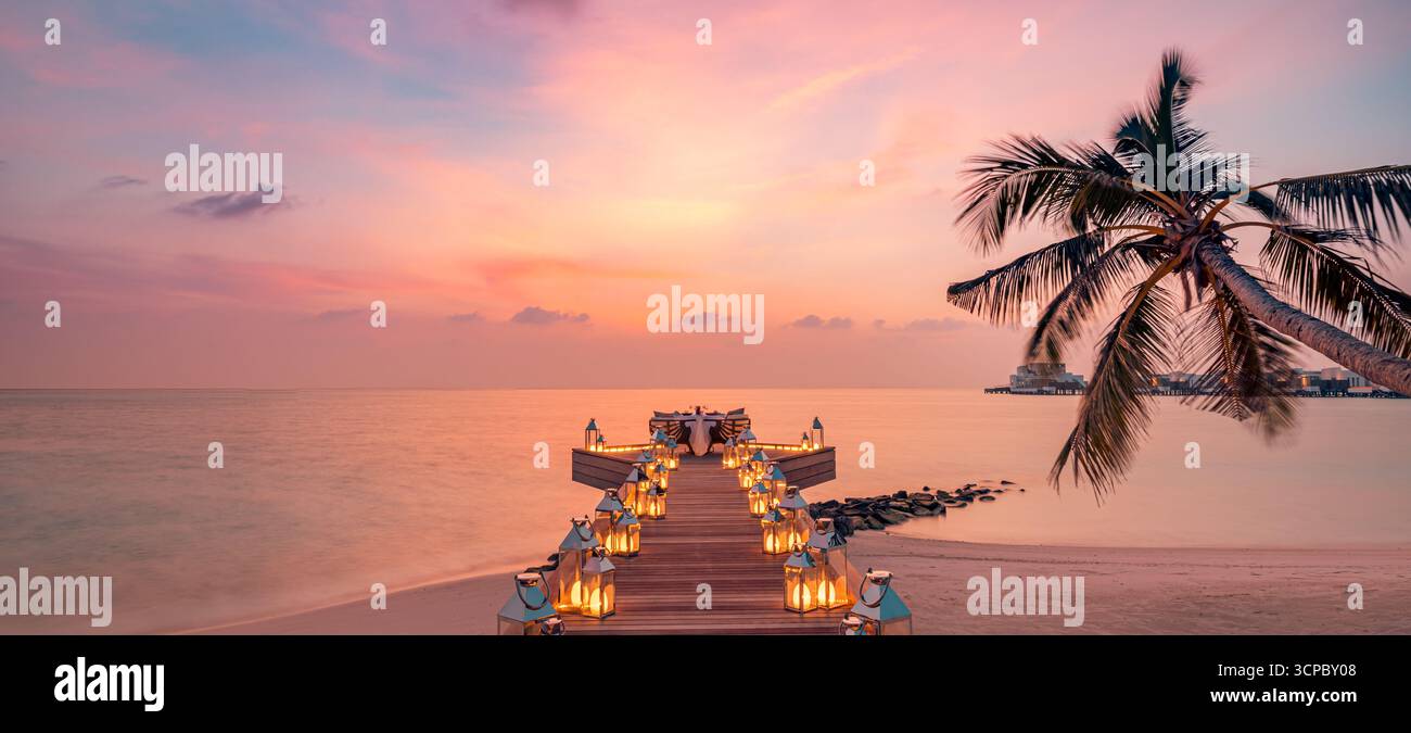 Cena romantica con tavolo panoramico a lume di candela, palme, vista mare sullo sfondo. Love Couple Honeymoon Anniversary Luxury Destination Dining Foto Stock
