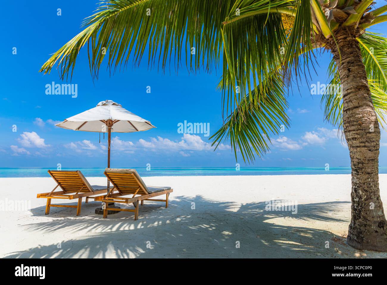 Splendida spiaggia soleggiata su un'isola tropicale paradisiaca. Amate il tempo libero di coppia, sedie, ombrellone, destinazione luna di miele. Fantastiche vacanze estive con cielo blu Foto Stock