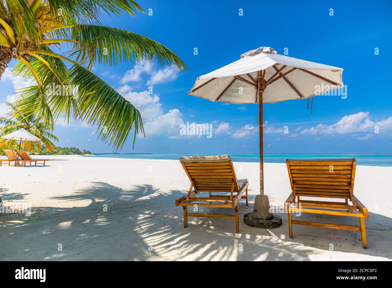Splendida spiaggia soleggiata su un'isola tropicale paradisiaca. Amate il tempo libero di coppia, sedie, ombrellone, destinazione luna di miele. Fantastiche vacanze estive con cielo blu Foto Stock