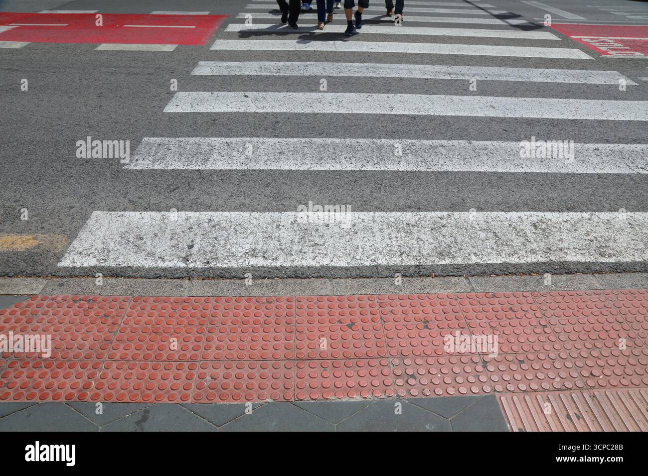 Pavimentazione tattile (blocchi tenji) presso l'attraversamento pedonale a Benidorm, Spagna. Foto Stock