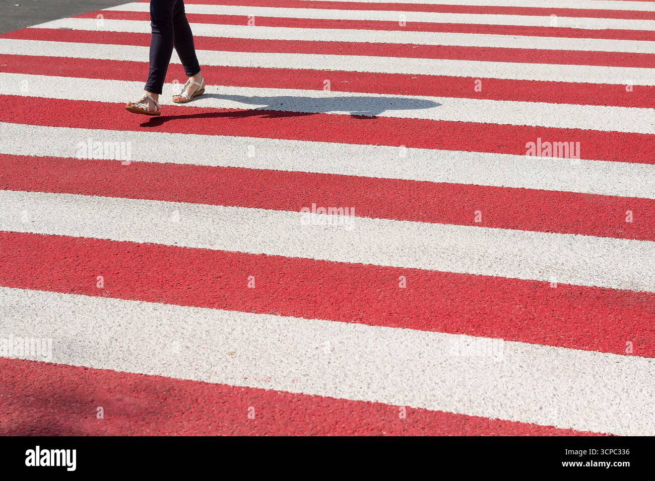 Gambe della donna che attraversa la strada sull'incrocio in superficie. Traffico Foto Stock