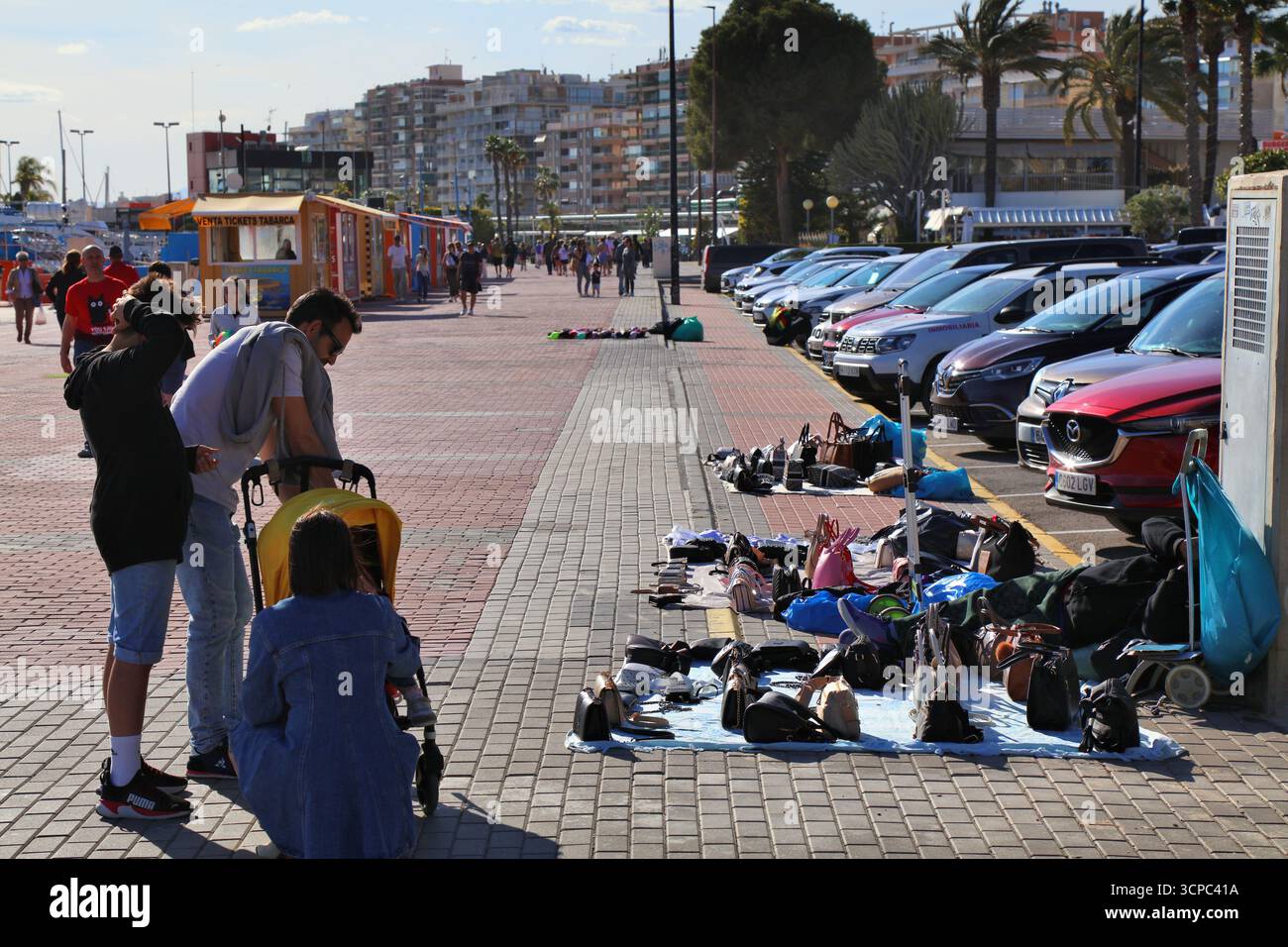 SANTA POLA, SPAGNA - 17 APRILE 2025: Le persone guardano false borse firmate vendute illegalmente da uno stand temporaneo a Santa Pola, nella provincia di Alicante, Spa Foto Stock