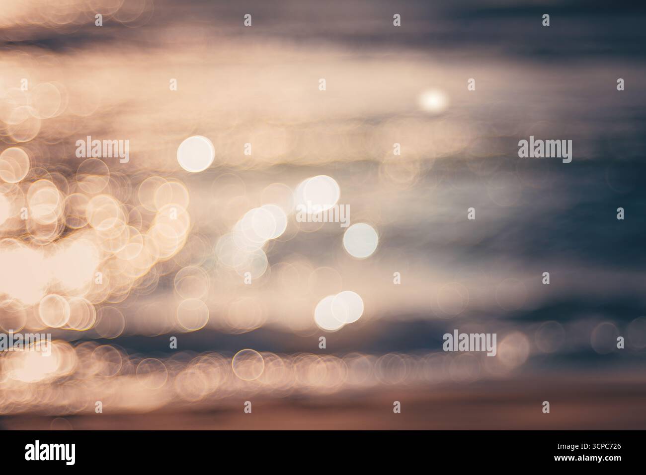 Morbido sfondo sfocato di Sunset Beach Glow con riflessi di luce bokeh sull'acqua calmo Foto Stock