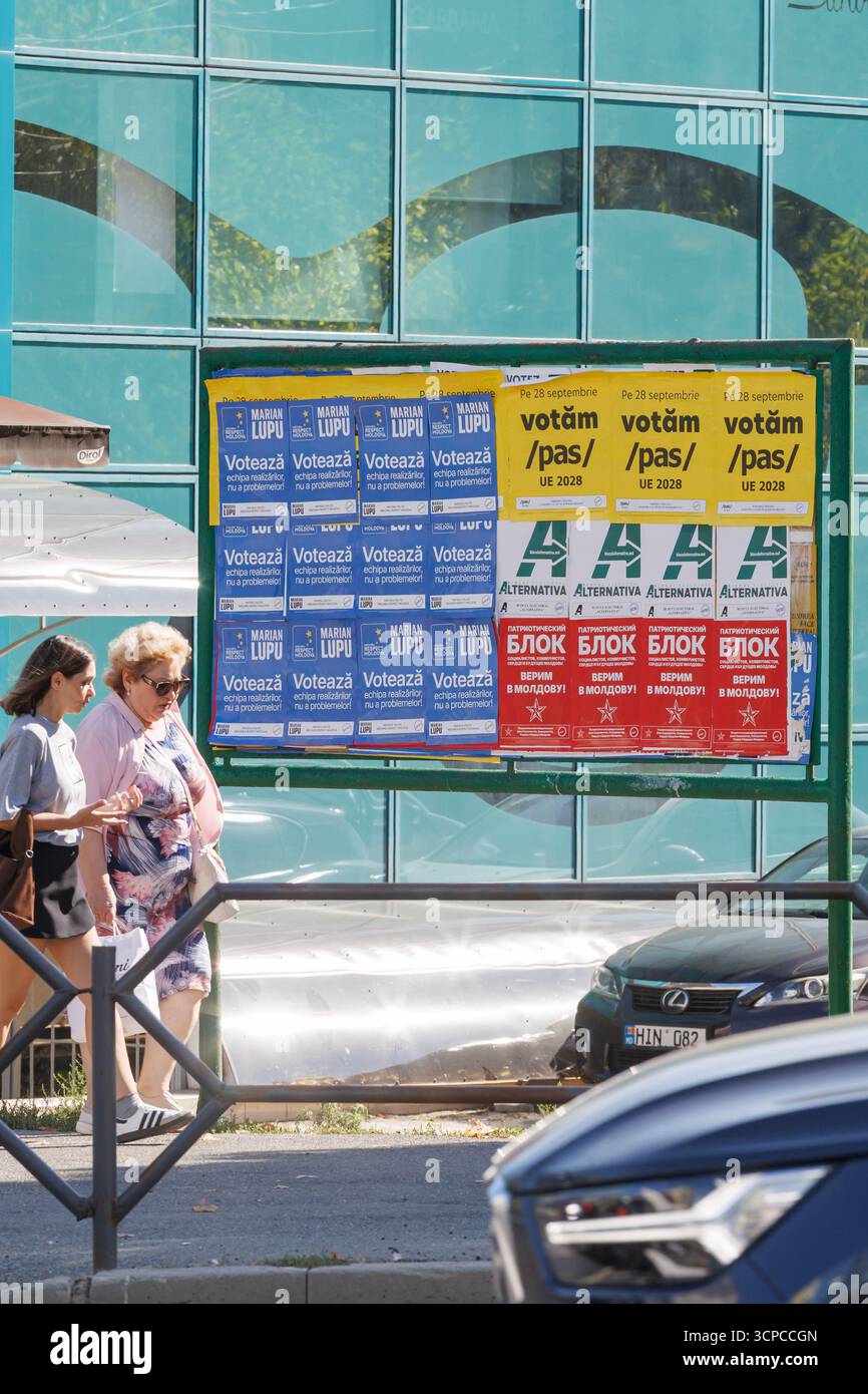 24 settembre. Chisinau, Moldavia. Donne che passano i manifesti della campagna elettorale. Scena urbana di strada con Consiglio per la campagna elettorale. Foto Stock
