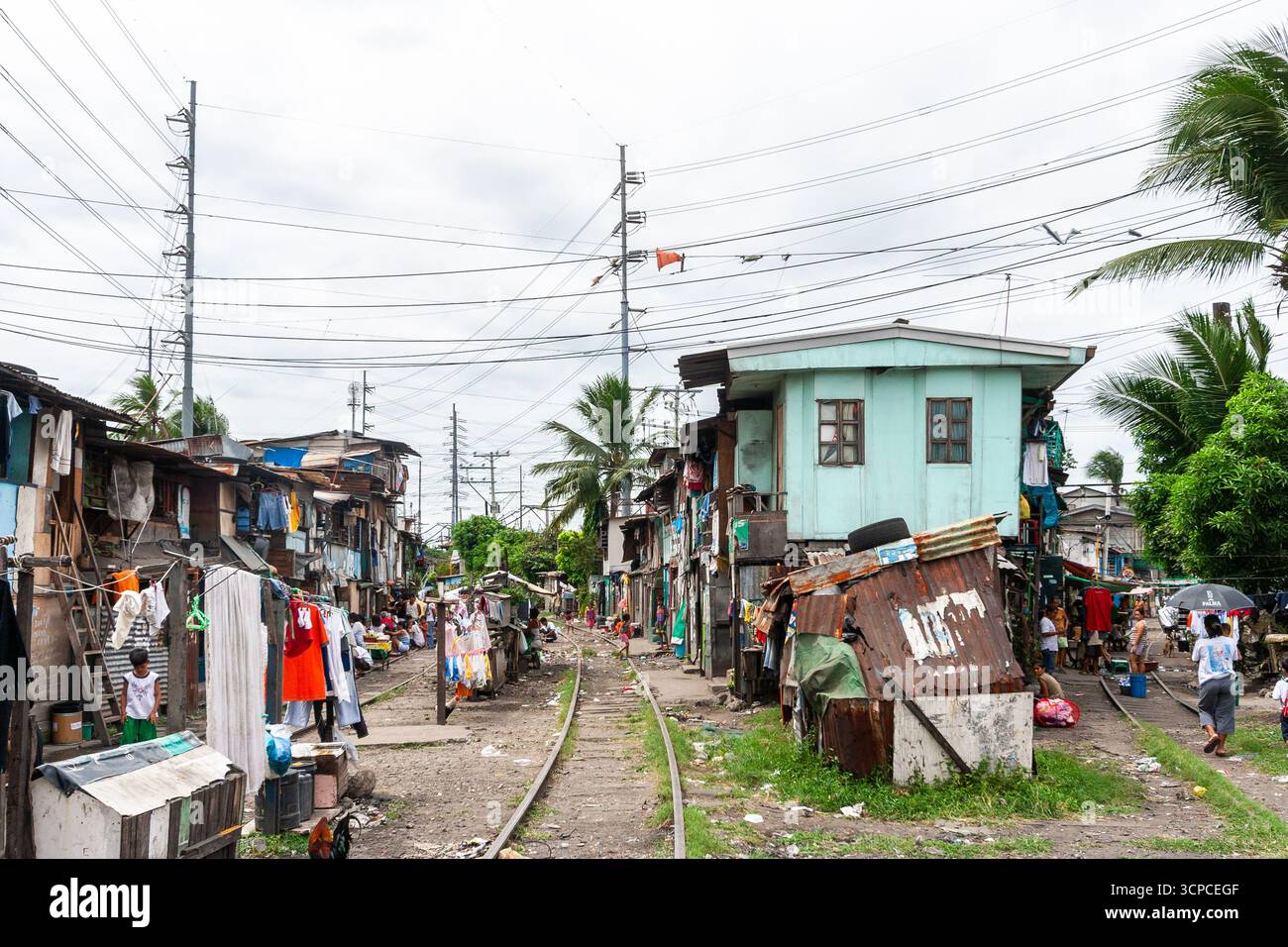 Alloggi in baraccopoli lungo una ferrovia a Manila, nelle Filippine Foto Stock