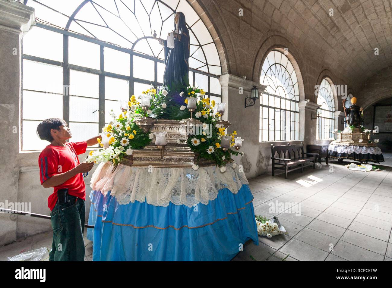 Un uomo decora una carrozza processionale con un'immagine di un santo agostiniano al monastero di San Agustin, Intramuros, Manila Foto Stock