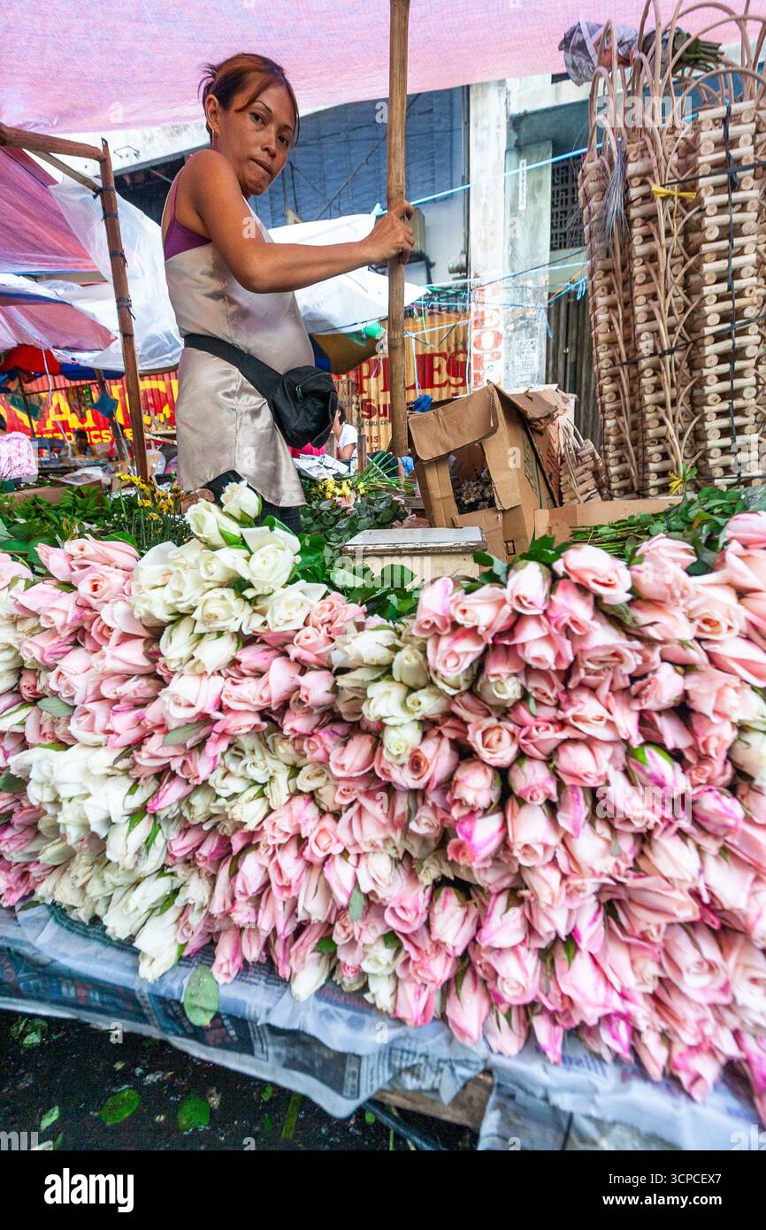 Un venditore locale in un affollato mercato dei fiori a Cebu, Filippine Foto Stock