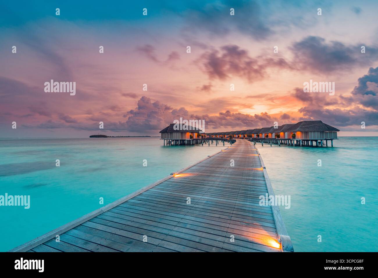 Le meravigliose ville sull'acqua al tramonto del molo delle Maldive hanno condotto delle luci. Baia della laguna sull'oceano, nuvole di cielo soleggiato. Viaggio di lusso, la migliore destinazione esotica background Foto Stock