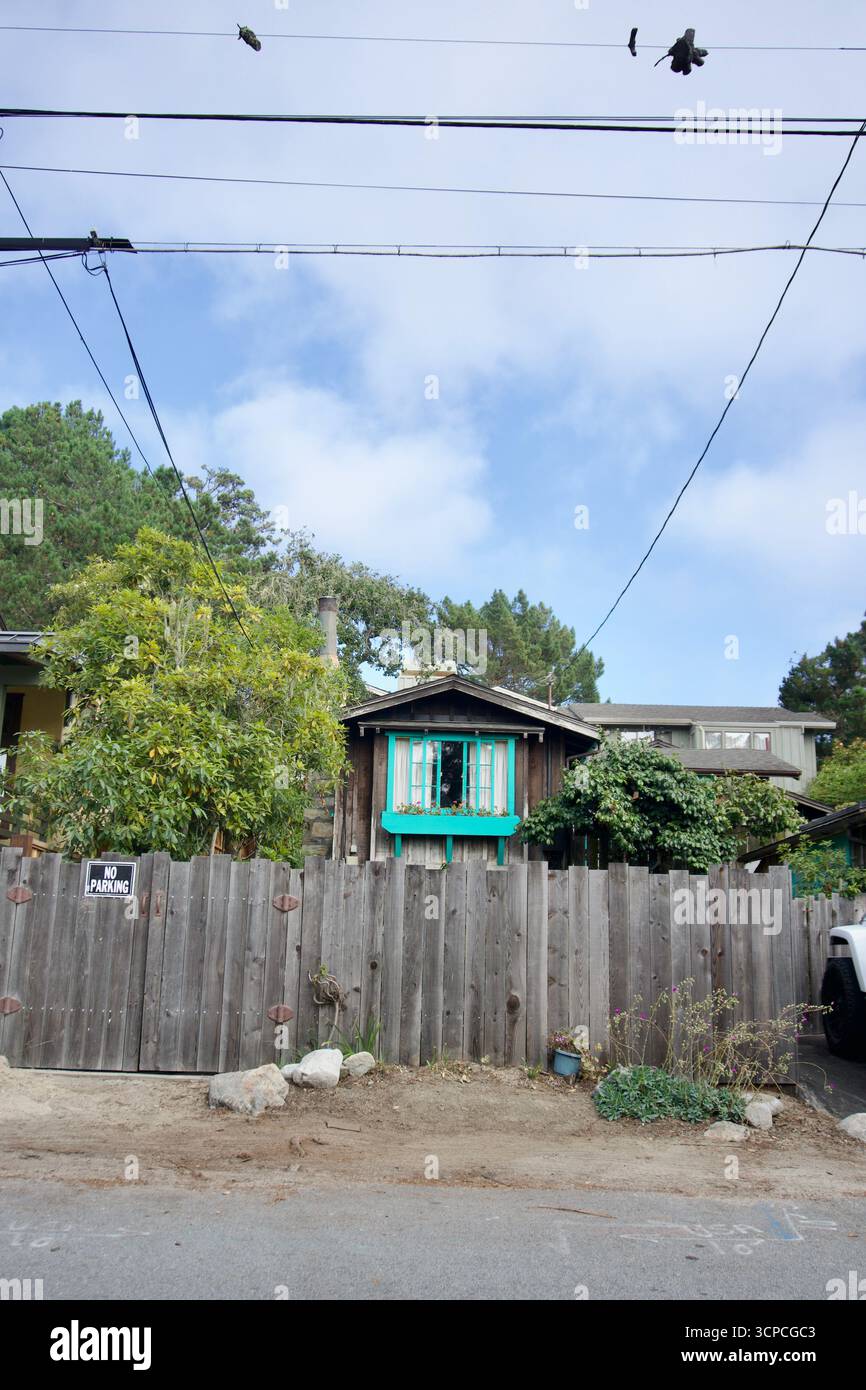 Capanna rustica con tende turchesi e recinzione giardino Foto Stock