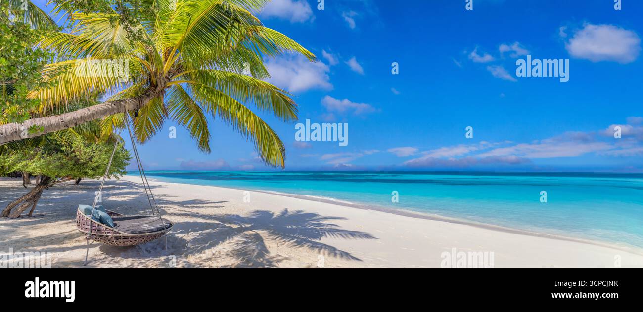 Splendida spiaggia tropicale con vista sul mare e sul cielo. Vacanze estive palme altalena amaca paradiso isola carta da parati. Le migliori spiagge tranquille e tranquille offrono una vista panoramica Foto Stock