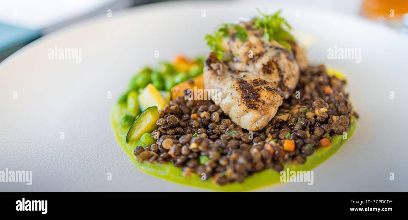 Ambiente gastronomico di lusso con lenticchie e filetti di pesce, elegante piatto da ristorante gourmet, raffinata presentazione culinaria, concetto gastronomico di alta qualità Foto Stock