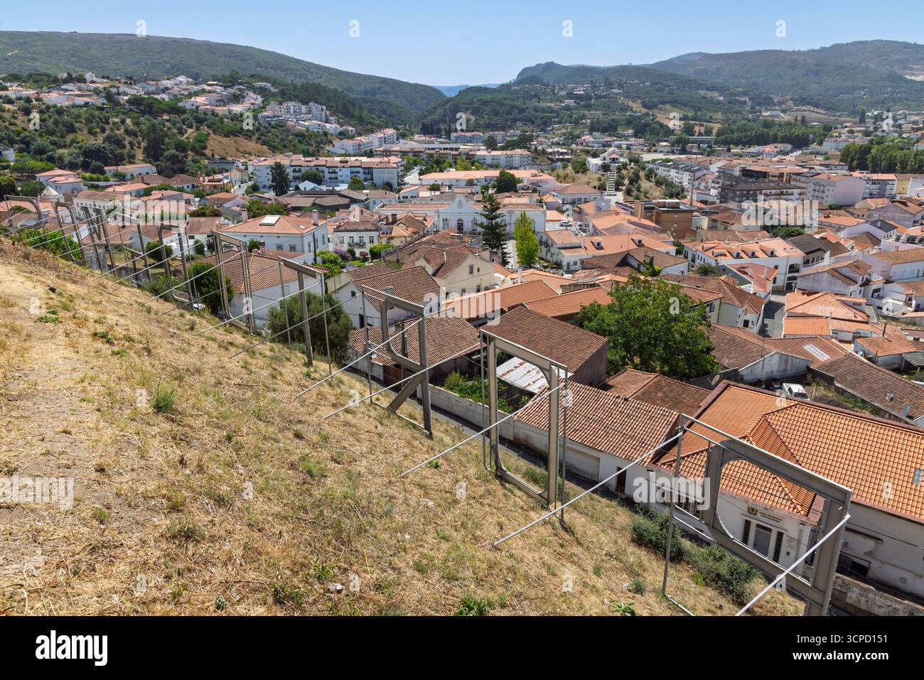 La vista dal castello di Porto de Mós mostra il paesaggio terrazzato e la città sottostante, con una recinzione di sicurezza in primo piano. Foto Stock