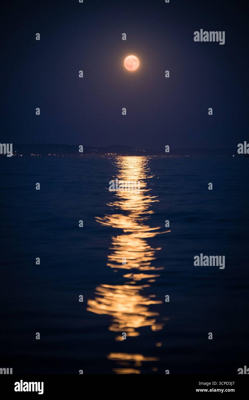 Luna piena e riflessi di luce sulle onde marine Foto Stock