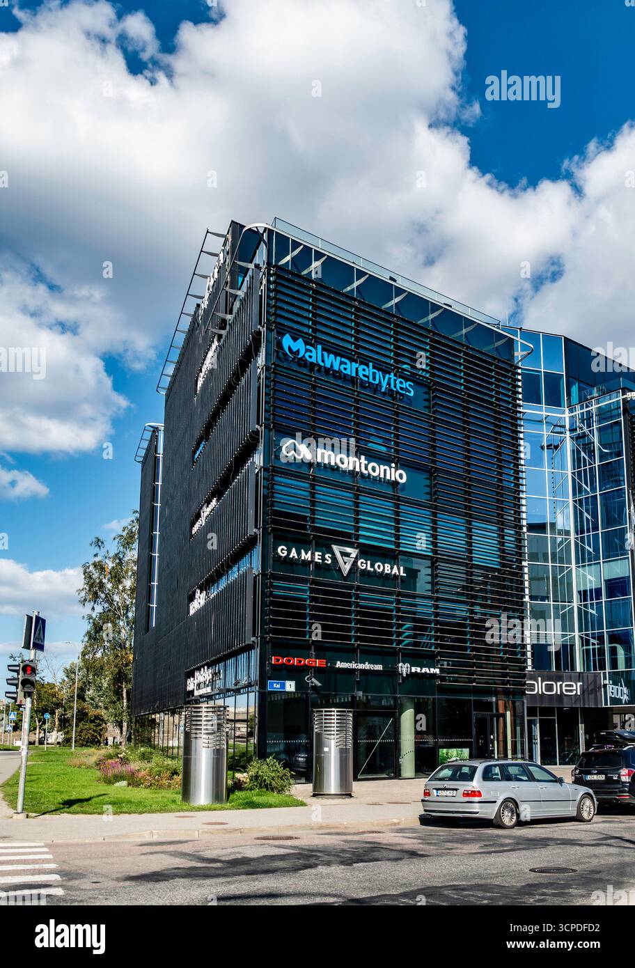 Moderno edificio per uffici a Tallinn, Estonia, con loghi aziendali tra cui Malwarebytes, Montonio, Games Global e Dodge showroom a livello della strada. Foto Stock