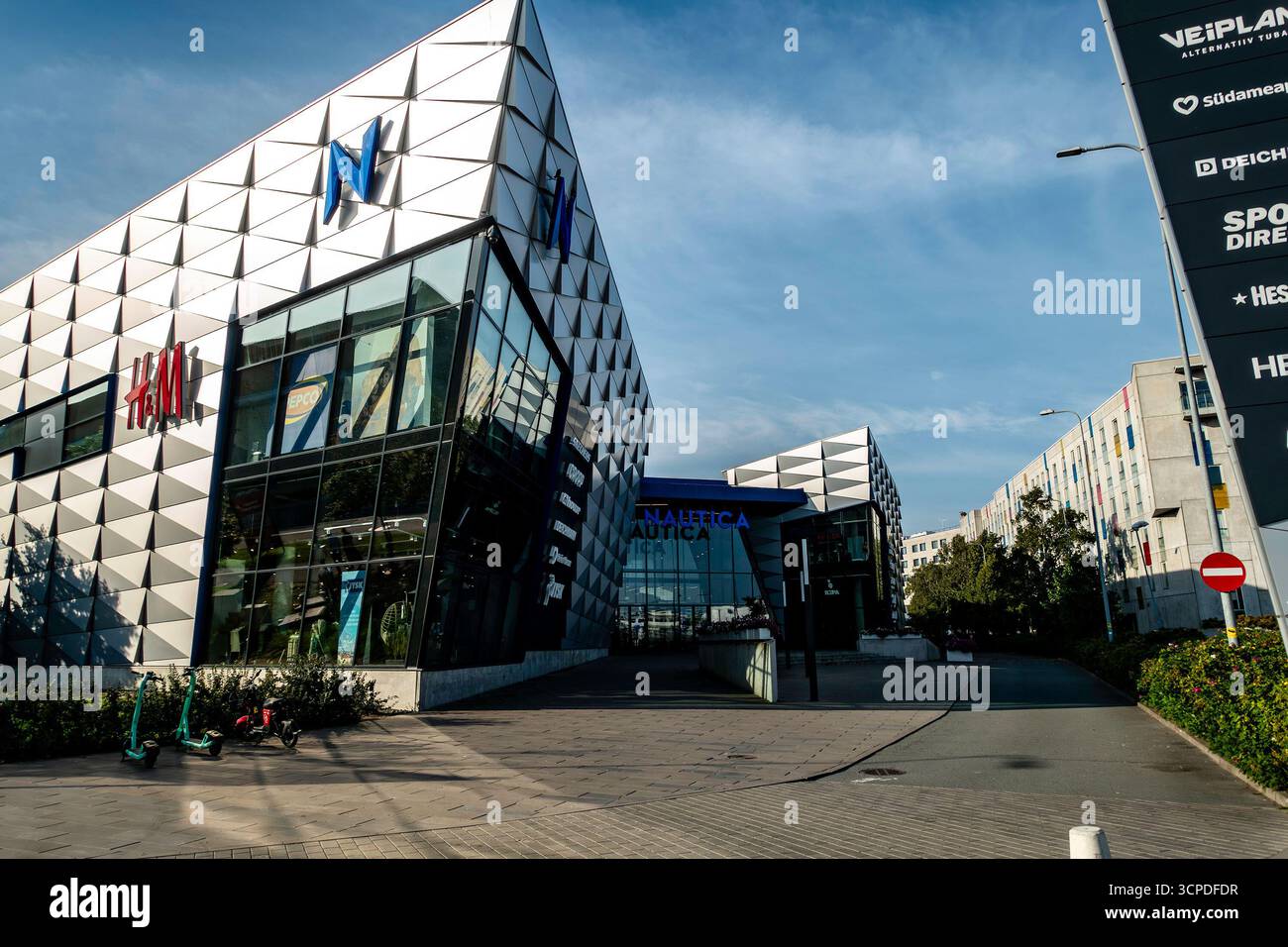 Centro commerciale Nautica a Tallinn, Estonia, con moderna facciata geometrica, ingresso al negozio H&M e cartellonistica di marca sotto un cielo azzurro. Foto Stock