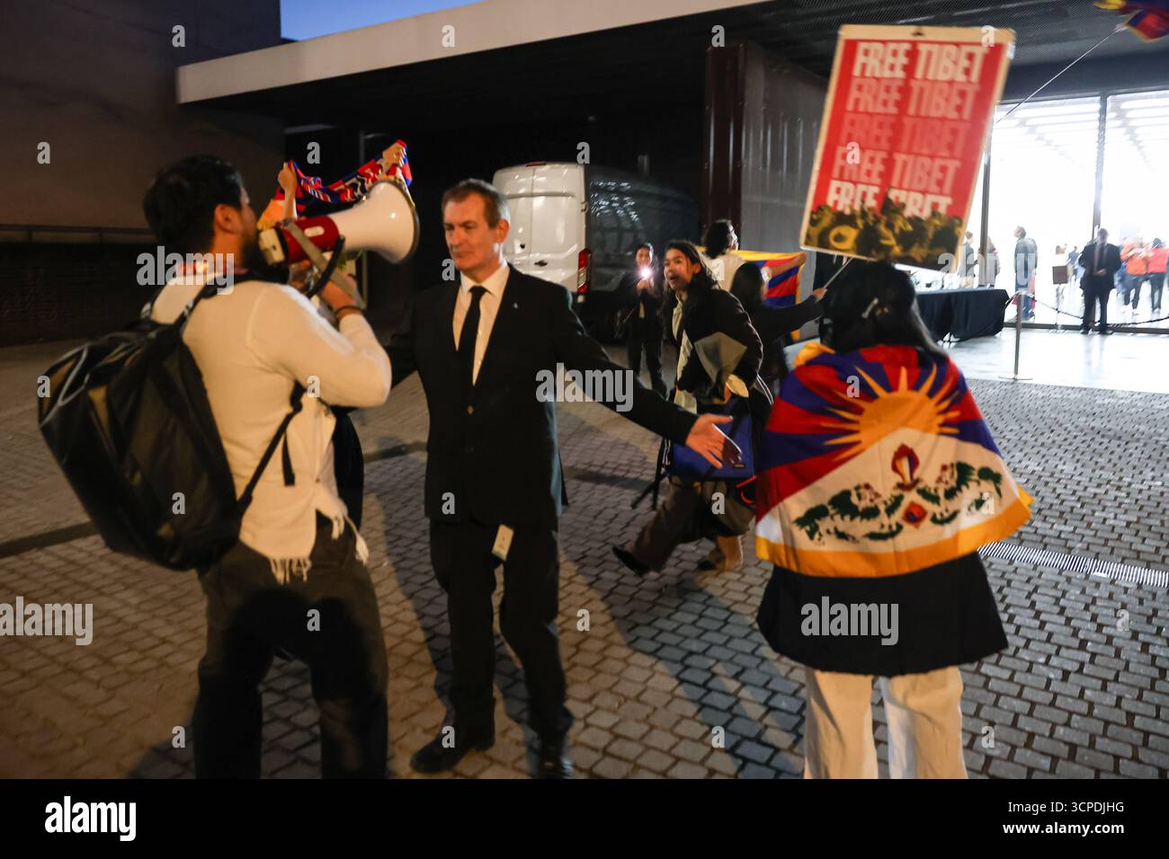 LONDRA, Regno Unito - 25 settembre 2025: I manifestanti tibetani vengono rimossi per sicurezza dalla galleria White Cube di Bermondsey, Londra, durante l'apertura della mostra dell'artista cinese Cai Guo-Qiang "Gunpowder and Abstraction 2015-2025". Gli attivisti sono entrati nella galleria per condannare il recente spettacolo pirotecnico di Cai a Shigatse, in Tibet, definendolo un atto di violenza culturale ed ecologica contro una montagna sacra tibetana sotto l'occupazione cinese. Diversi tibetani sono stati espulsi mentre la protesta ha evidenziato la controversia che circonda il lavoro dell'artista. Foto Stock