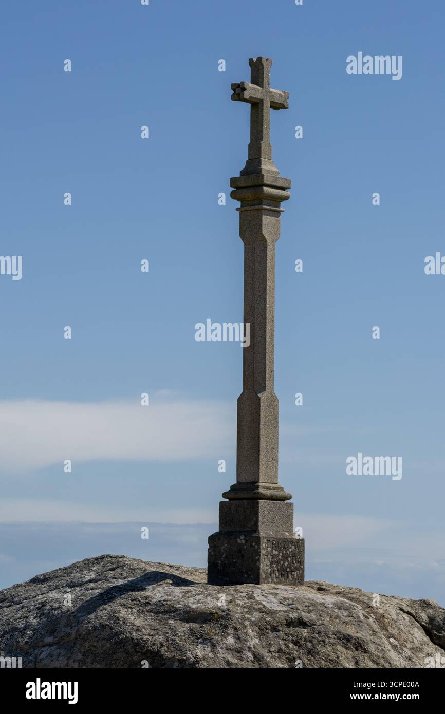 Scultura della Croce a Capo Finisterre, con splendide viste sull'Oceano Atlantico e scogliere. Famosa tappa finale del pellegrinaggio del cammino di Santiago Foto Stock