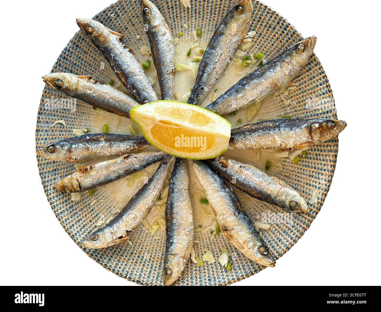 Sardine grigliate su piatto con fetta di limone - cucina mediterranea. Presentazione di pesce fresco, perfetto per piatti mediterranei, salutari e gourmet Foto Stock