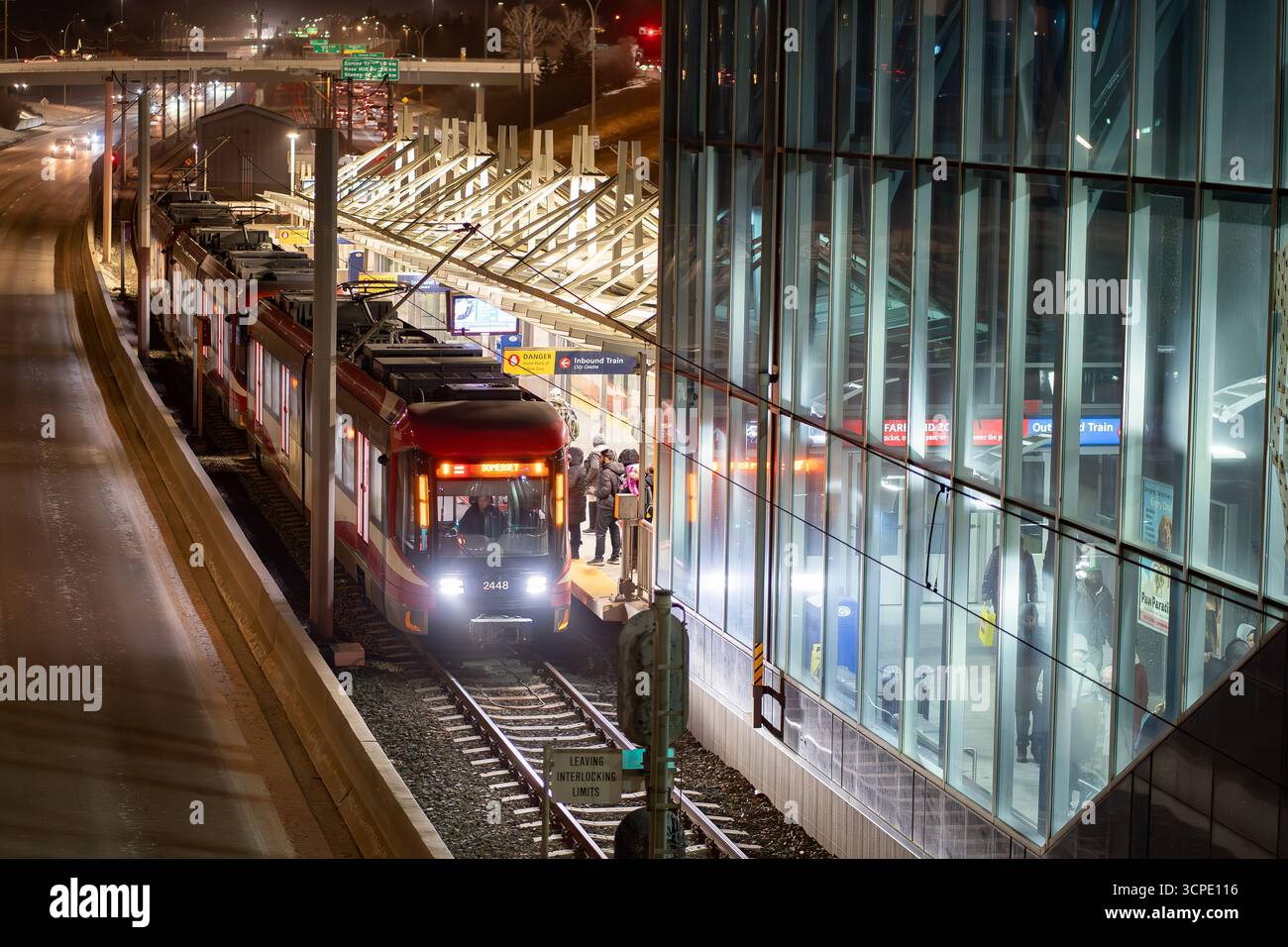 Calgary, Alberta Canada, 20 aprile 2025: Treno di transito rapido che raccoglie passeggeri durante la sera in un terminal di transito. Foto Stock
