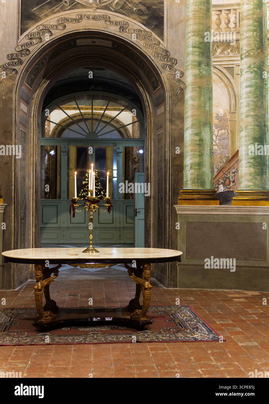 Candelabro ornato sul tavolo centrale nel vestibolo di Villa Palagonia, Bagheria, Sicilia. interni barocchi del xviii secolo con illuminazione decorativa Foto Stock