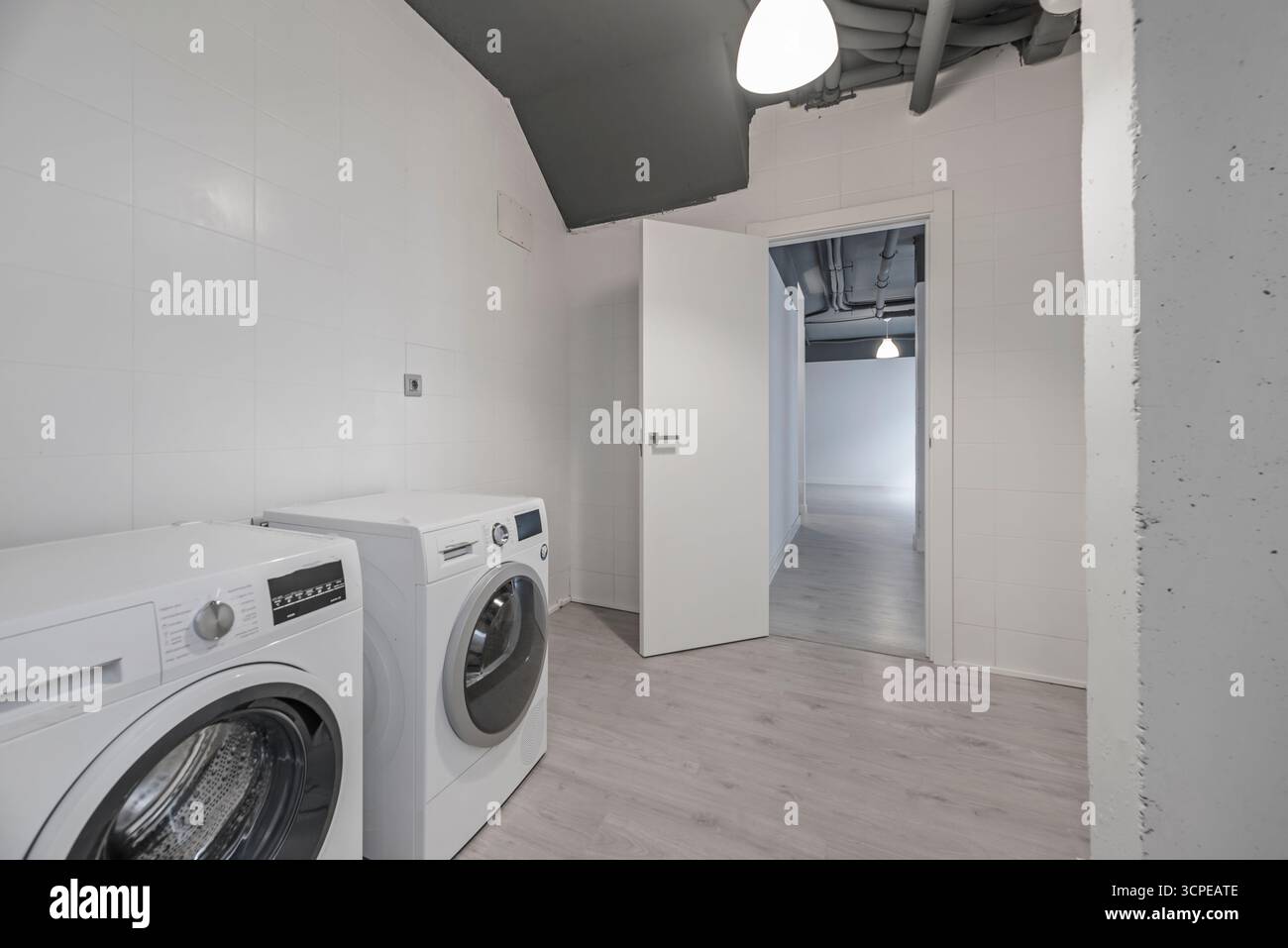Lavanderia dotata di lavatrice a caricamento frontale, caldaia a condensazione e armadi per lo smistamento degli indumenti sporchi Foto Stock