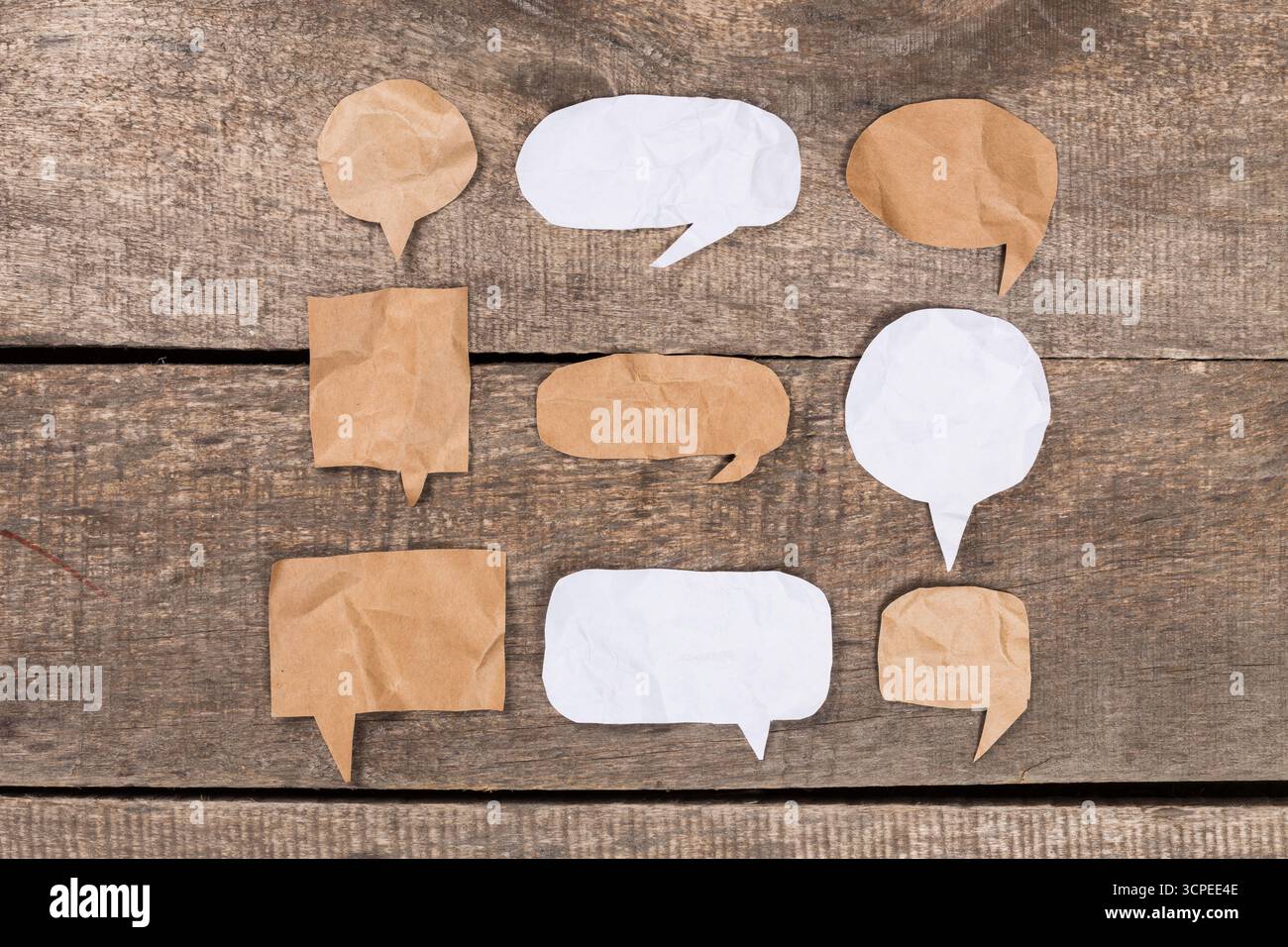 Piccole bolle di carta disposte su una superficie in legno per una comunicazione creativa Foto Stock