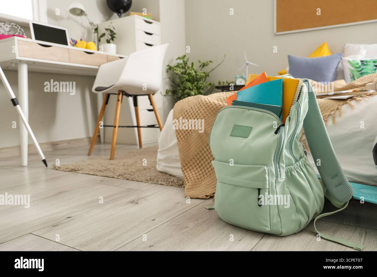 Zaino con quaderni sul pavimento nella camera dei bambini Foto Stock