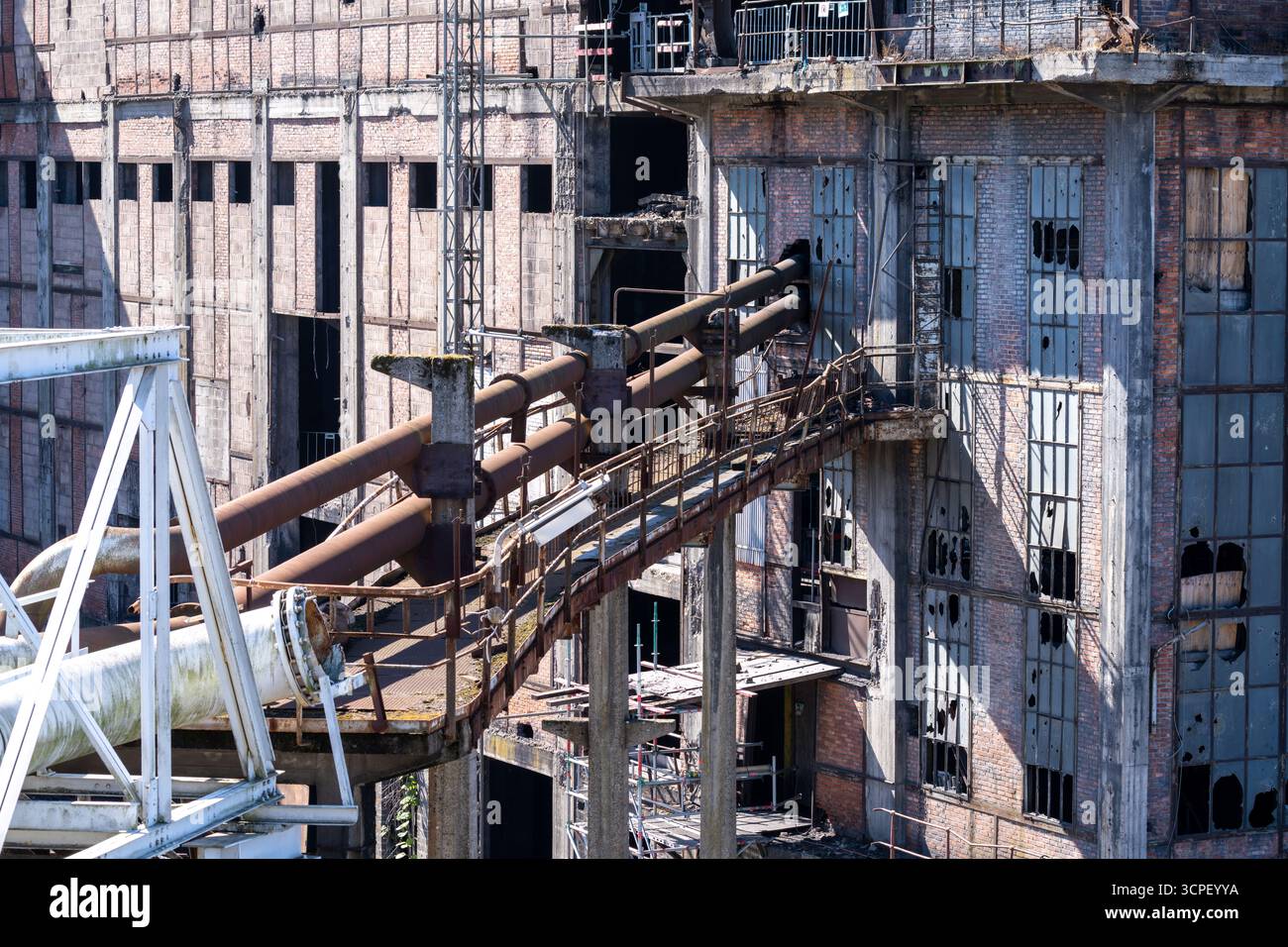 Impianto di lavaggio del carbone abbandonato con tubi industriali arrugginiti e facciata in cemento intempestivo, finestre rotte e architettura abbandonata, simbolo dell'industria industriale Foto Stock