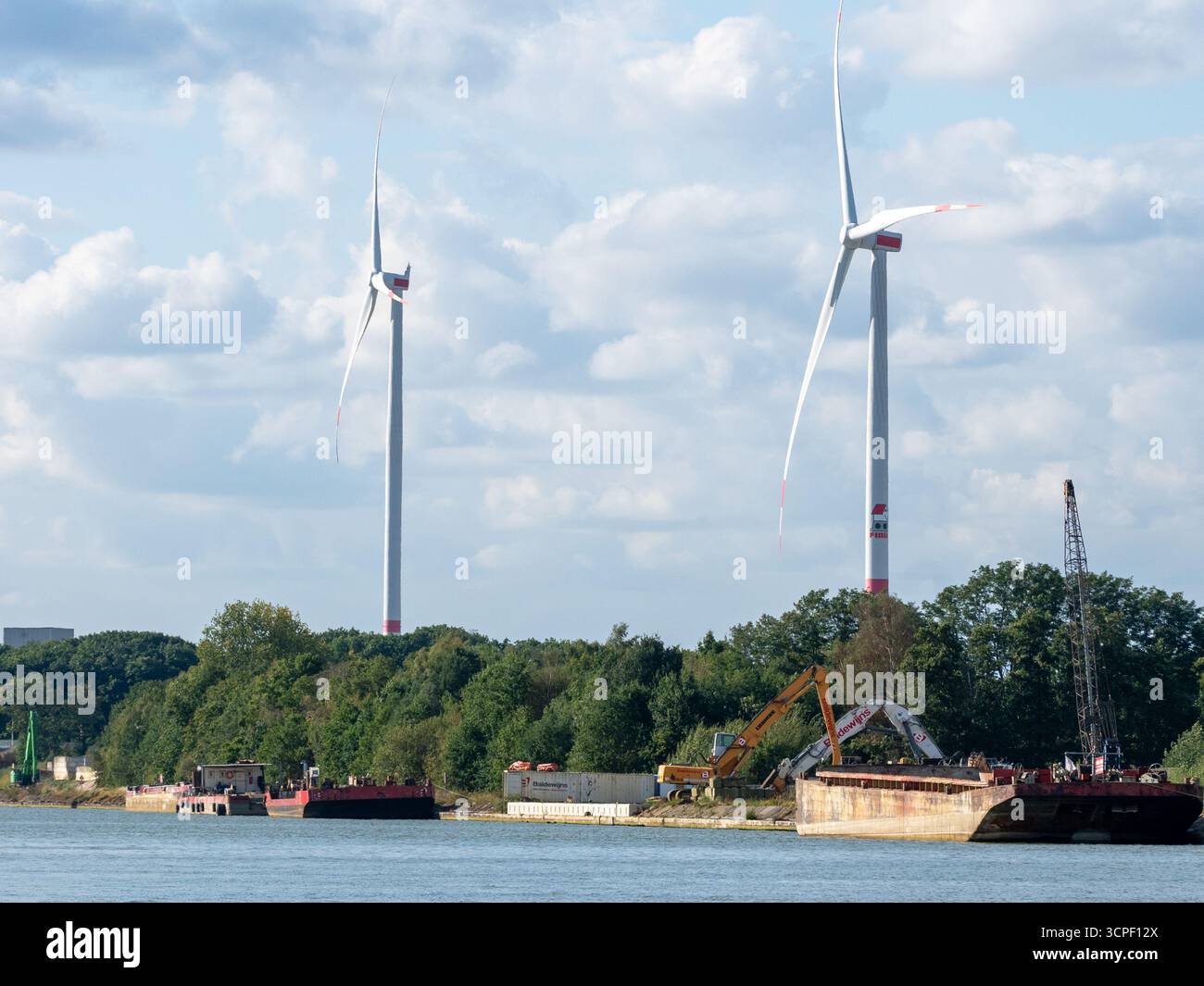 Turbine eoliche e chiatte industriali lungo il canale Albert in Belgio, combinando energia rinnovabile e trasporto per vie navigabili interne Foto Stock