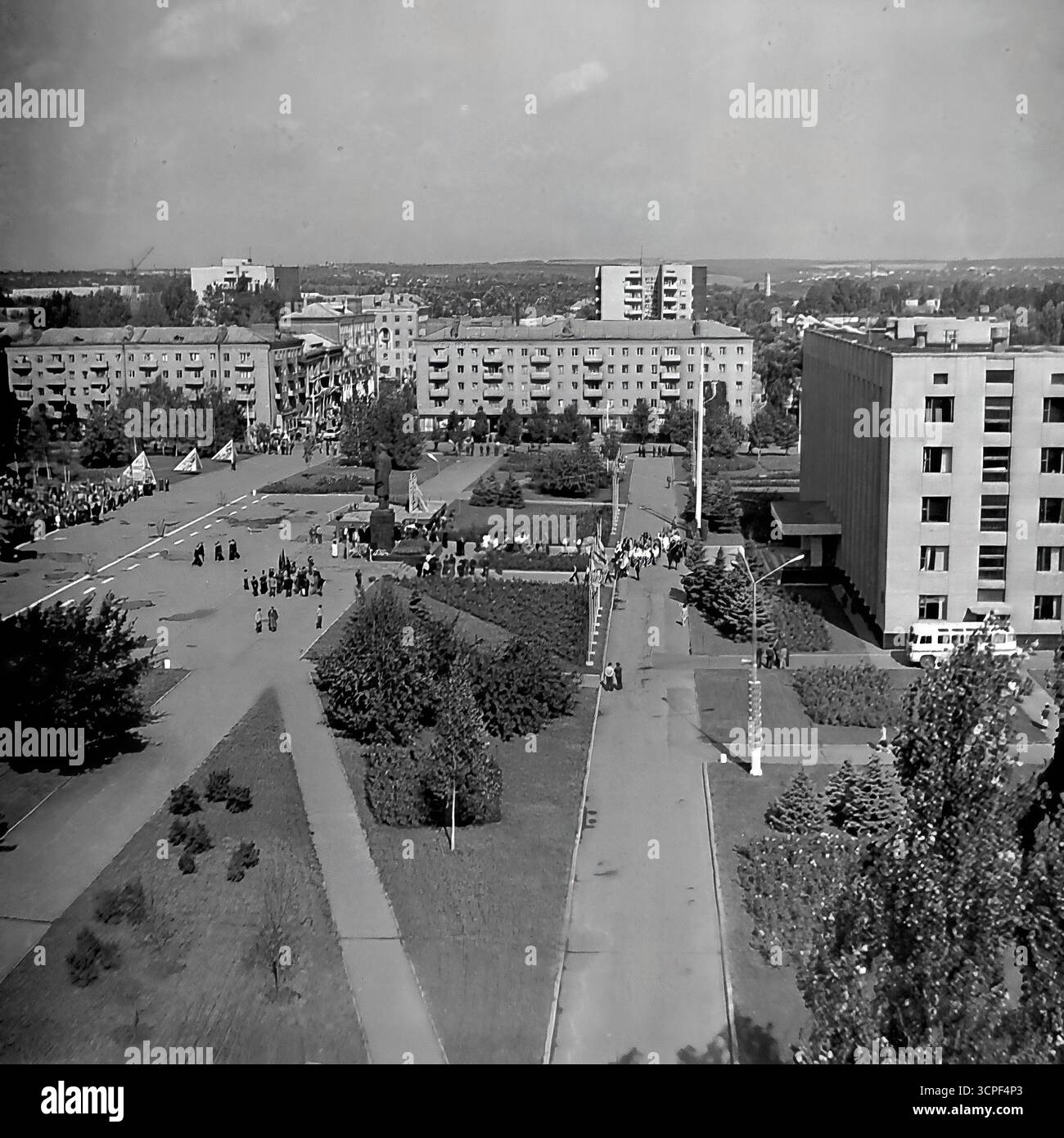 Una vista ad alto angolo cattura una dimostrazione pubblica su larga scala per una festa sovietica in Piazza della Rivoluzione d'ottobre (ora Piazza Soborna) a Sloviansk, RSS Ucraina, negli anni '1970 Questa foto d'archivio monocromatica mostra colonne di dimostranti riunite intorno al monumento centrale di Lenin, una tipica scena di una parata organizzata dallo stato come il giorno di maggio. La vista panoramica della piazza principale della città, circondata da edifici amministrativi e residenziali, incarna la vita ideologica e civica dell'URSS Foto Stock