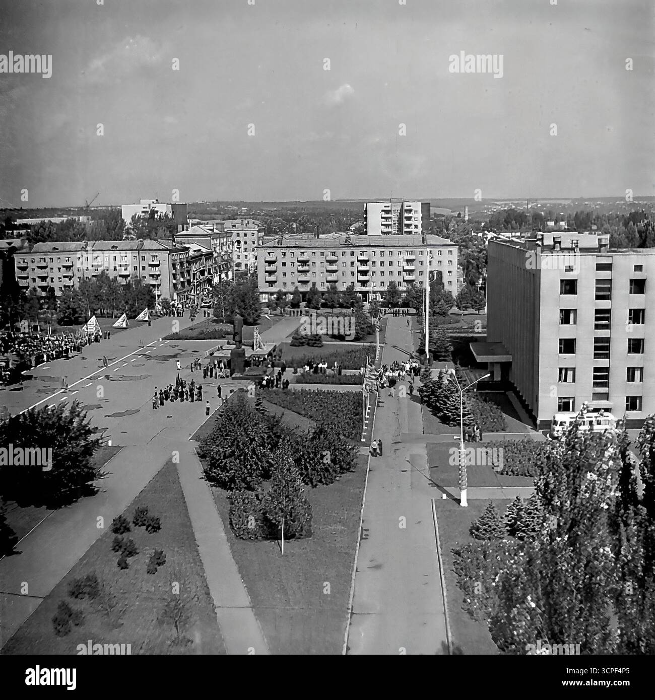 Una vista ad alto angolo cattura una dimostrazione pubblica su larga scala per una festa sovietica in Piazza della Rivoluzione d'ottobre (ora Piazza Soborna) a Sloviansk, RSS Ucraina, negli anni '1970 Questa foto d'archivio monocromatica mostra colonne di dimostranti riunite intorno al monumento centrale di Lenin, una tipica scena di una parata organizzata dallo stato come il giorno di maggio. La vista panoramica della piazza principale della città, circondata da edifici amministrativi e residenziali, incarna la vita ideologica e civica dell'URSS Foto Stock