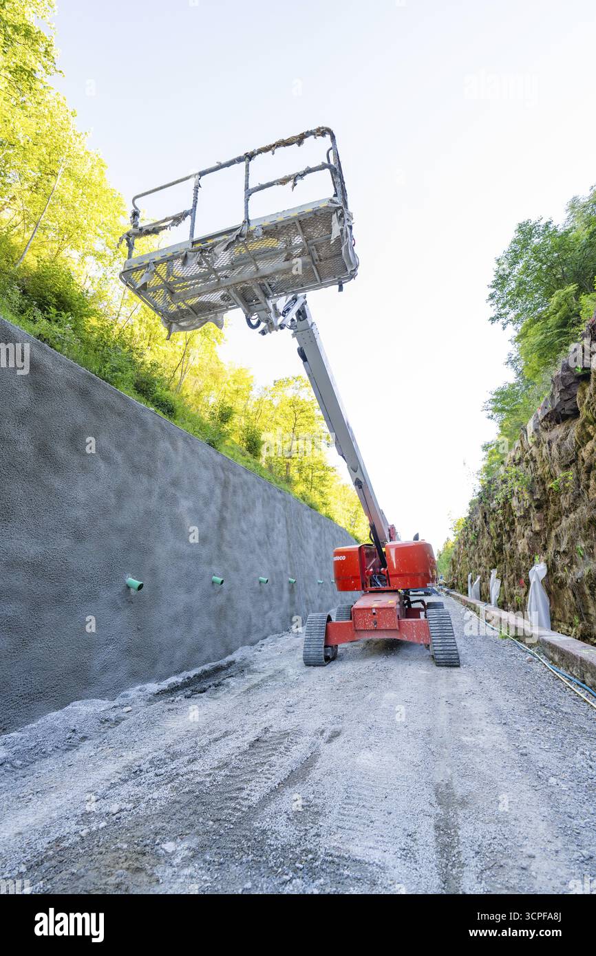 La piattaforma di sollevamento si erge di fronte a una parete di cemento nel cantiere della foresta, Hermann Hessebahn, Calw, Germania Foto Stock