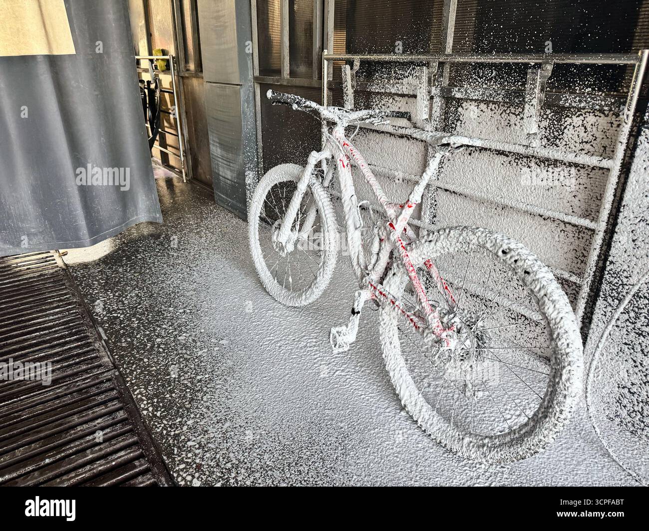 Lavare una bicicletta con schiuma in un autolavaggio self-service. Cura della bicicletta. Foto Stock