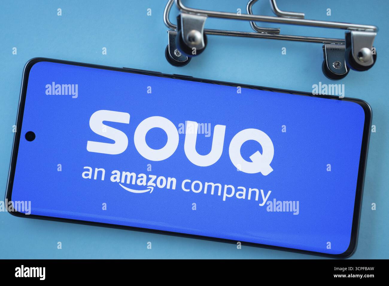 Dhaka, Bangladesh - 3 luglio 2025: Schermo dello smartphone con il logo Souq con le ruote del carrello su sfondo blu Foto Stock