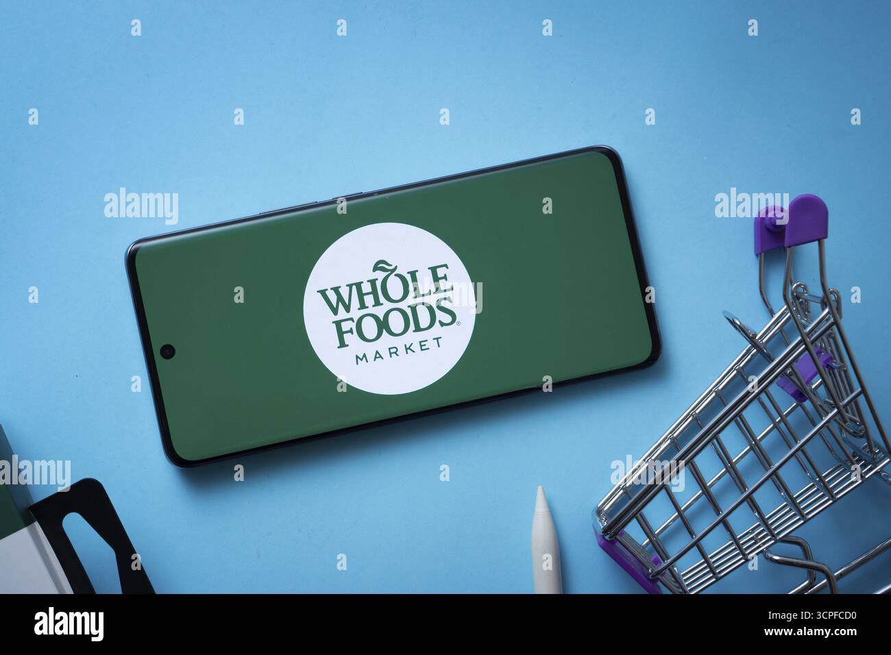 Dhaka, Bangladesh - 3 luglio 2025: Smartphone con logo Whole Foods Market e carrello su sfondo blu Foto Stock