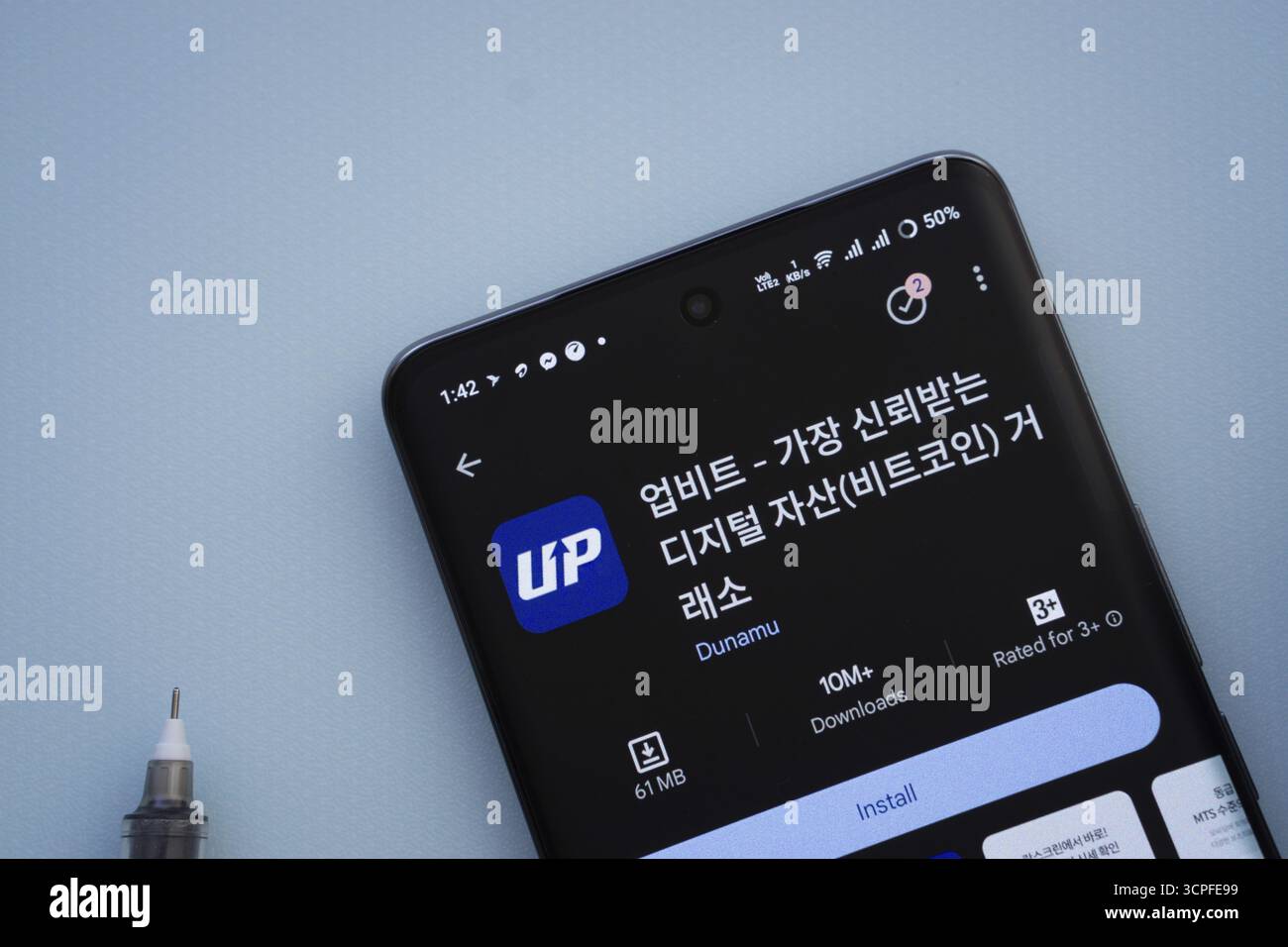 Dacca, Bangladesh - 29 maggio 2025: Su una superficie blu, uno smartphone visualizza l'app Upbit all'interno di Google Play Store Foto Stock