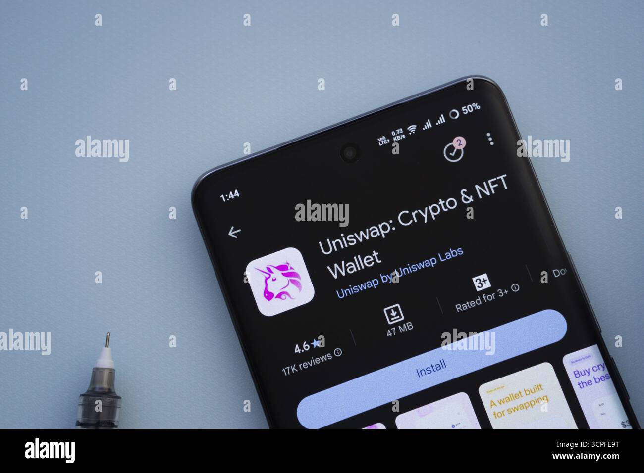 Dacca, Bangladesh - 29 maggio 2025: Su una superficie blu, uno smartphone visualizza l'app Uniswap all'interno del Google Play Store Foto Stock