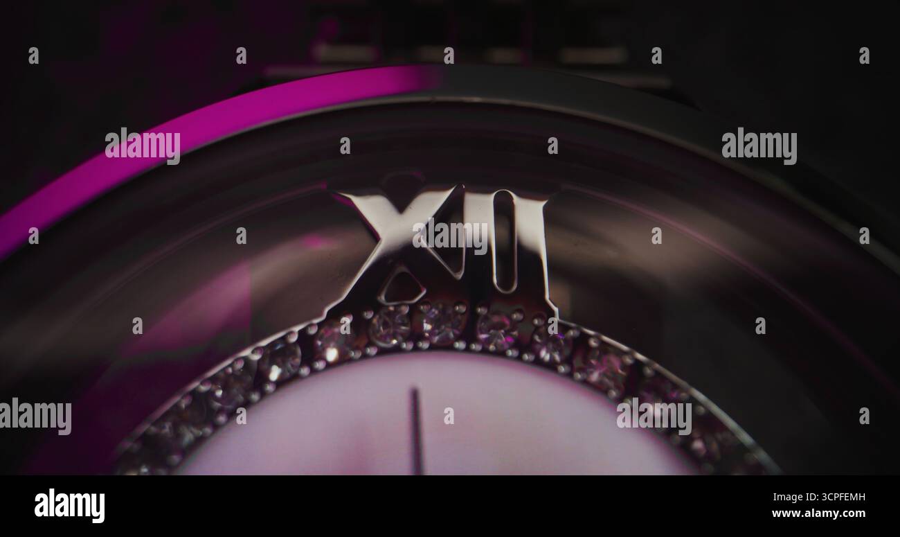 Primo piano di un elegante orologio da polso con lunetta in pietra preziosa e bracciale metallizzato che mostra l'ora esatta. Accessorio che simboleggia il design di lusso, la precisione, la moda e il concetto simbolico del tempo in stile moderno. Foto Stock