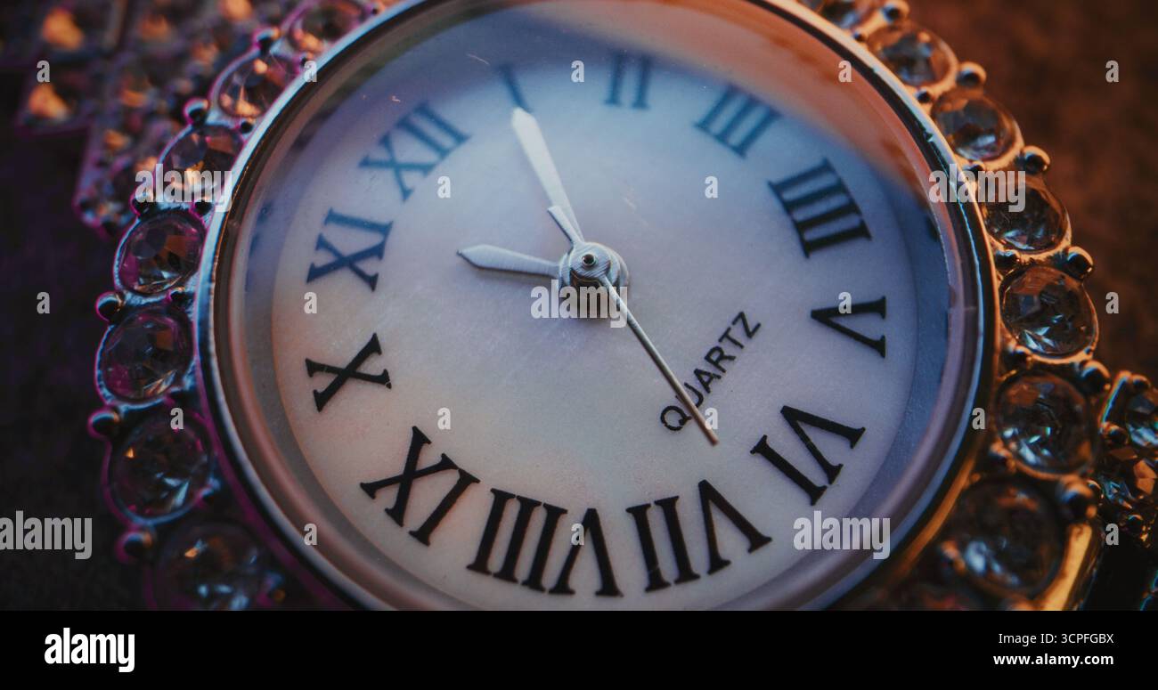 Primo piano dell'orologio decorativo con numeri romani e cornice gioiellata decorata che mostra l'ora esatta. Design elegante che simboleggia eleganza, lusso, puntualità, tradizione. Concetto simbolico di misurazione del tempo Foto Stock