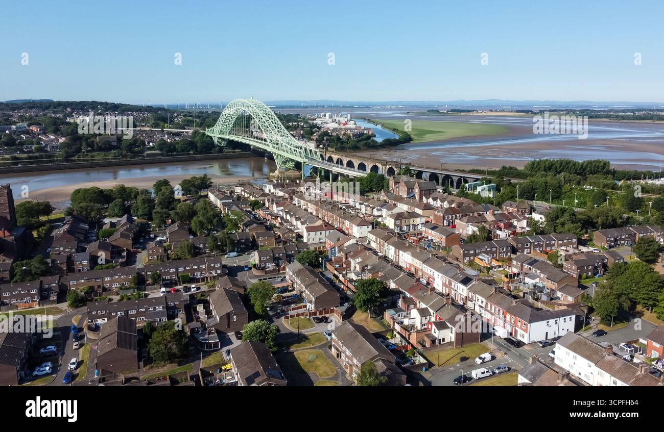 Veduta aerea del Runcorn Bridge che attraversa il fiume Mersey con alloggi residenziali a Widnes Foto Stock