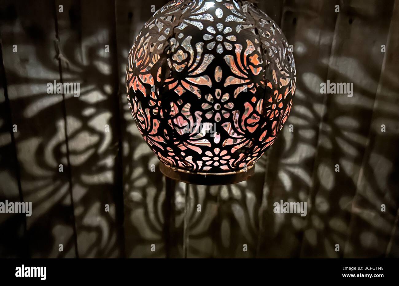Lanterna notturna che proietta ombre luminose Foto Stock