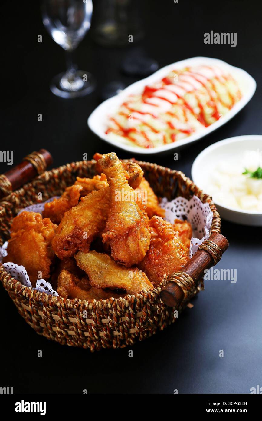 Cestino di pollo fritto coreano con contorni su Dark Table Foto Stock