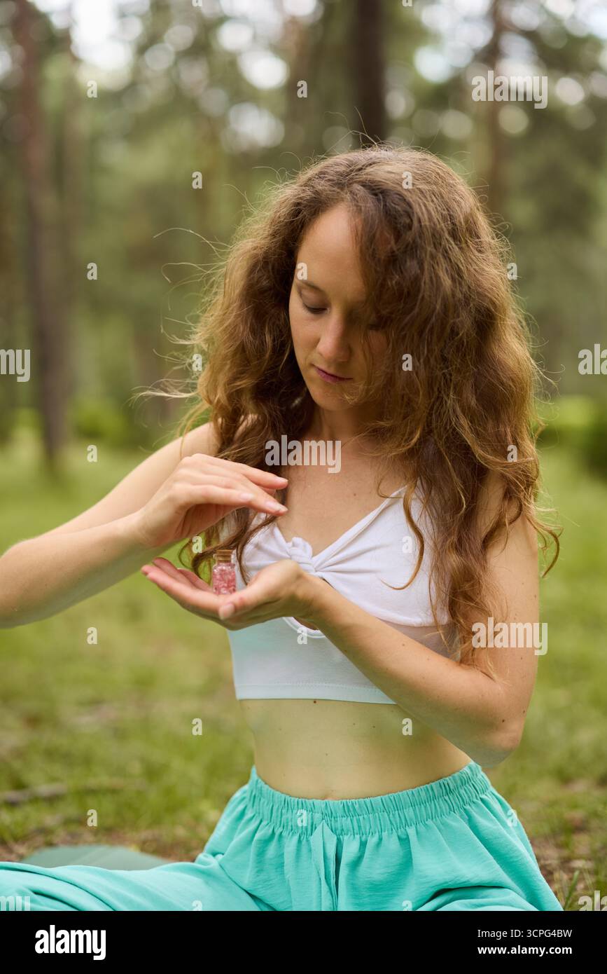 Donna che pratica la consapevolezza in un ambiente calmo della foresta Foto Stock